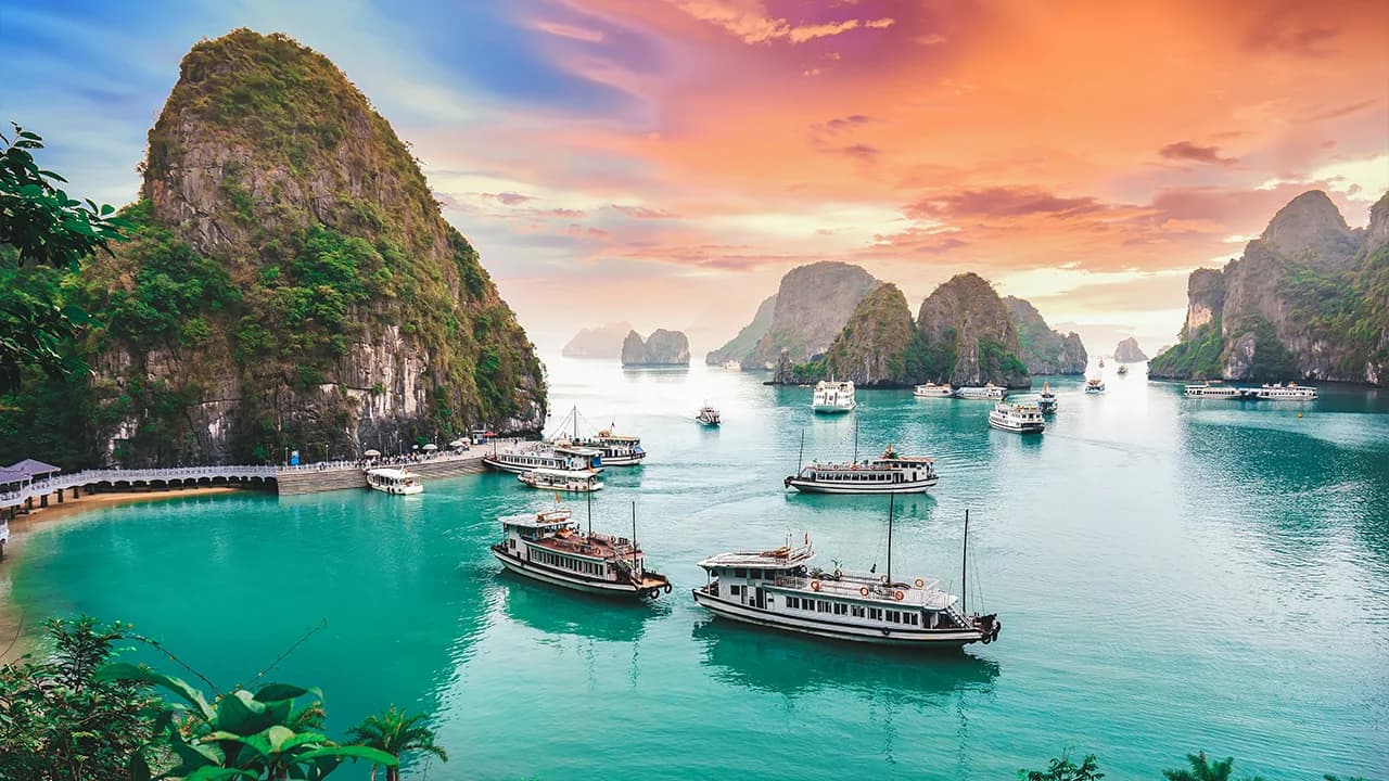 Rowing boat through limestone arch in Halong Bay